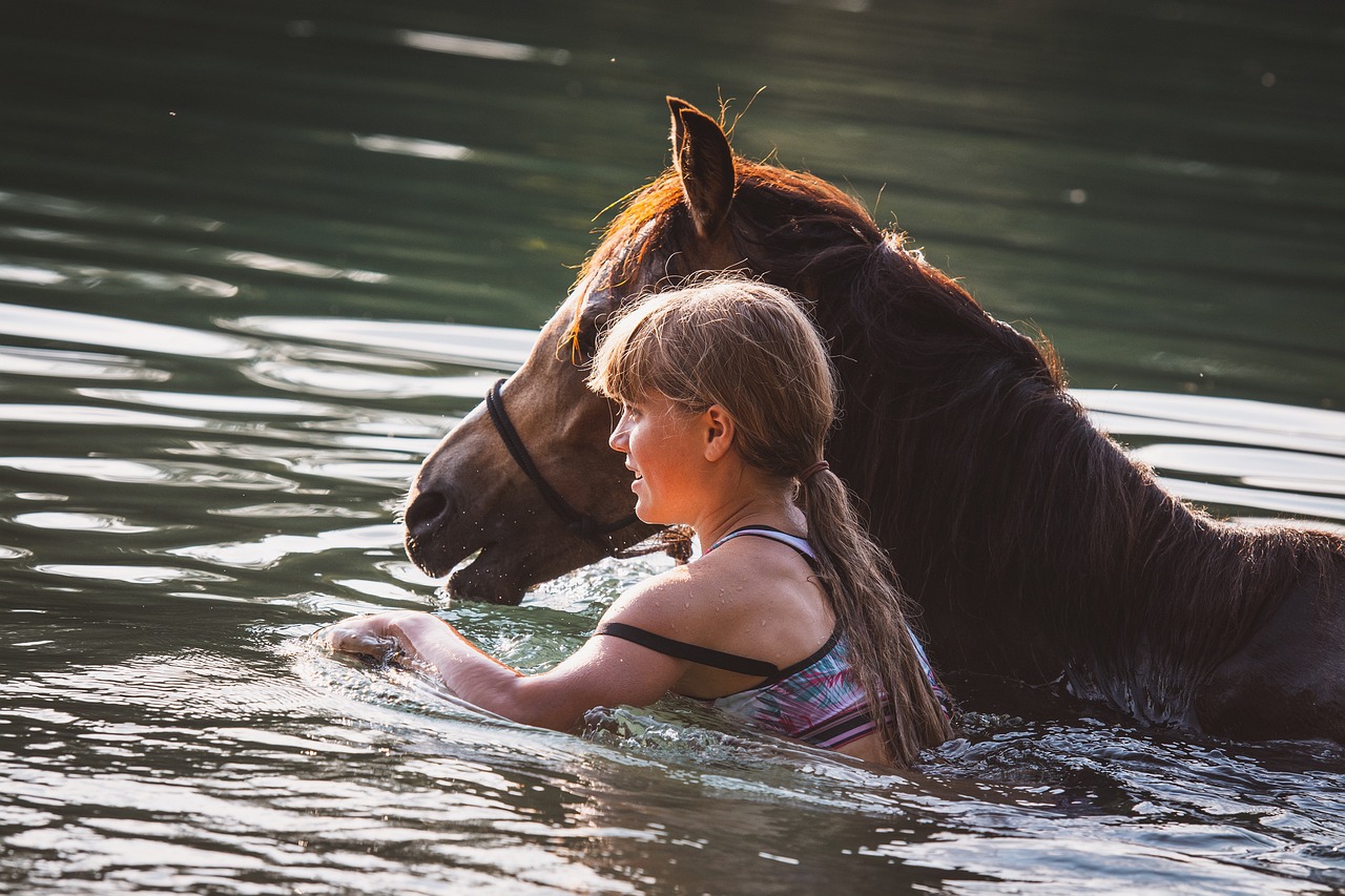 girl and horse swimming in the lake